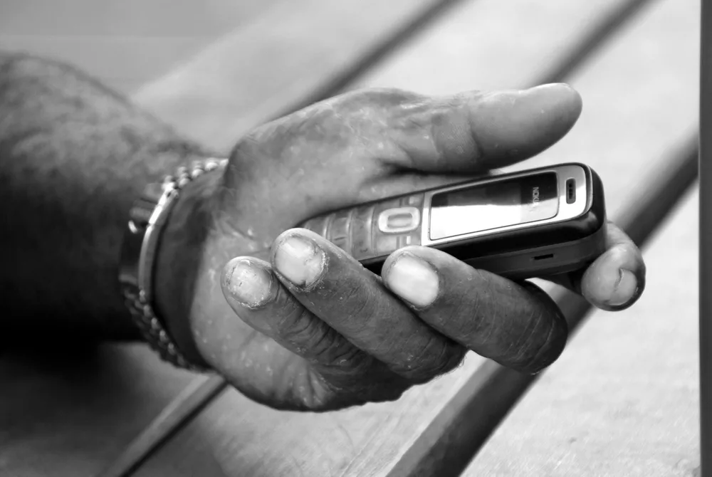 Una mano con un teléfono; la línea móvil en Paraguay se maneja sobre todo desde el celular